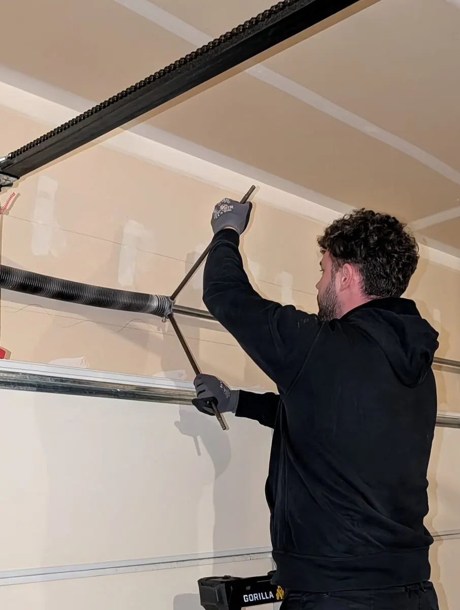 Technician servicing a garage door track
